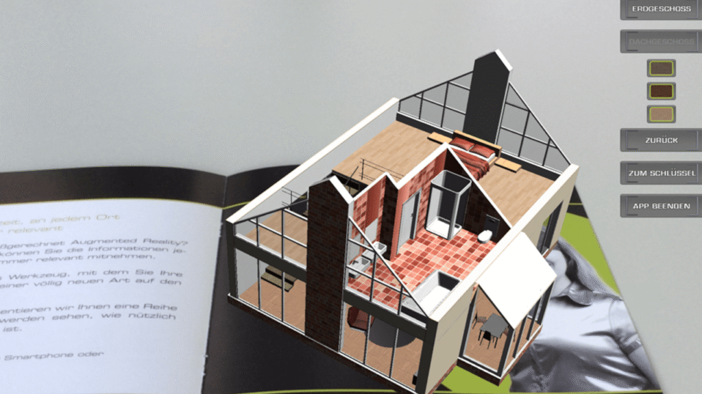 AR-3D-Modell eines Gebäudes, das aus einem gedruckten Katalog über ein mobiles Gerät projiziert wird.
