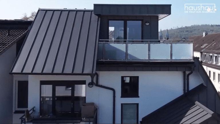 Moderne Dachkonstruktion aus Aluminium-Falzbändern auf einem Wohnhaus, gefilmt aus der Außenperspektive.